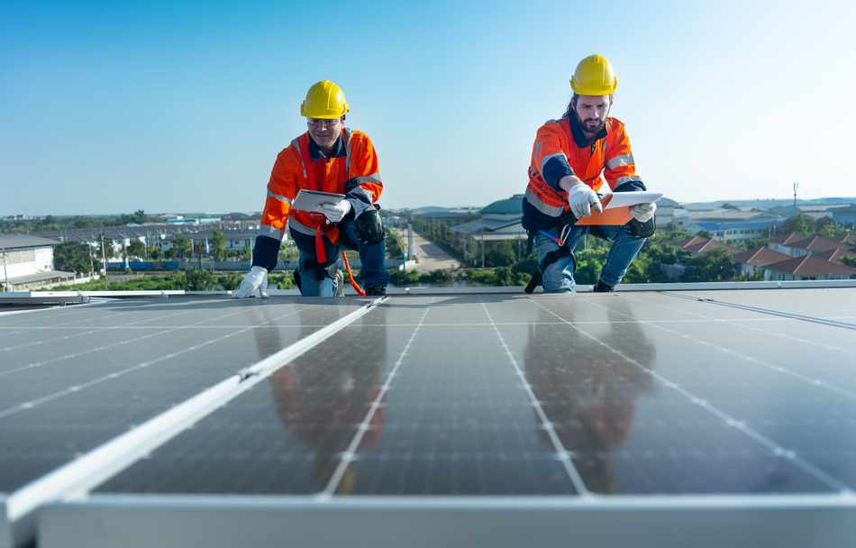 Técnicos revisando paneles solares en una instalación fotovoltaica durante tareas de distribución fotovoltaica y gestión de sistemas de energía solar.